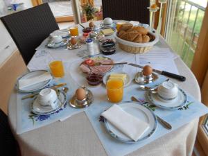 a breakfast table with eggs and bread and glasses of orange juice at Haus Panorama in Steinberg am Rofan
