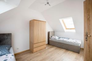 1 dormitorio con 2 camas y armario de madera en Domki całoroczne Jesionowscy, en Kudowa-Zdrój