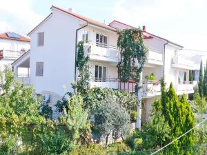 a white building with trees in front of it at Apartments Ceja near sea in Medulin