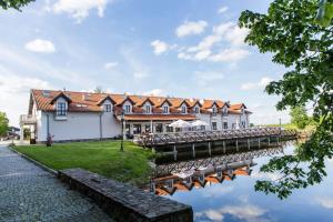 budynek z mostem obok zbiornika wodnego w obiekcie Palac Mortegi Hotel & SPA- Restauracja Szlachecka, SPA, Basen, Sauny, Jazda Konna, Mini Zoo- Luksus, Relaks i Przyroda w jednym! w mieście Lubawa