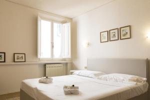 een witte slaapkamer met een bed met twee handdoeken erop bij Mario's apartament with AC and wifi in Lucca