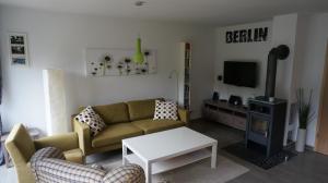 a living room with a couch and a tv at Lakeside House Strasen in Wesenberg
