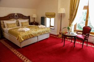 a bedroom with a large bed and a red carpet at Pałac Mortęgi Hotel & SPA in Lubawa