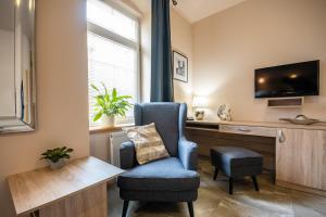 a living room with a chair and a desk at Penzion a Restaurace Stará Roudná in Plzeň