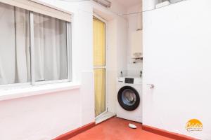 a laundry room with a window and a washing machine at Villa Lola by Cadiz Time in Cádiz