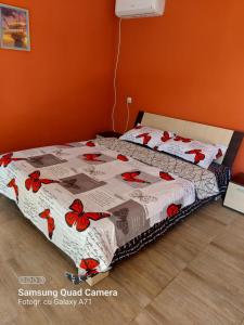 a bedroom with two beds with red flowers at La Botezatu in Tuzla