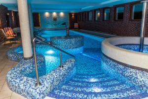 basen z niebieskimi płytkami na podłodze w obiekcie Palac Mortegi Hotel & SPA- Restauracja Szlachecka, SPA, Basen, Sauny, Jazda Konna, Mini Zoo- Luksus, Relaks i Przyroda w jednym! w mieście Lubawa