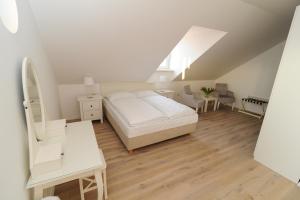 a white bedroom with a bed and a desk at B&B Castanea in Kostanjevica na Krki
