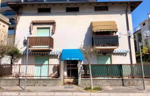 a building with two balconies and a blue awning at Villa Filiberta in Grado