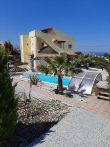 a house with a swimming pool next to a building at Plaque Panoramic SeaView Villa in Chania Town