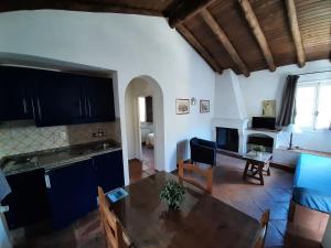 a kitchen and living room with a table and a couch at Finca Valbono Apartamentos Rurales y Hotel in Aracena