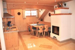 a kitchen and dining room with a table and a fireplace at Almpartments Rosengasse in Oberaudorf