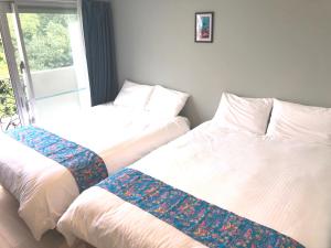 那覇市にあるTenpoint Hotel OKOUのベッド2台が隣同士に設置された部屋です。