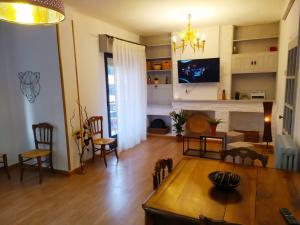 ポンフェラーダにあるApartamento Ponsferrataのテーブルと暖炉のあるリビングルーム