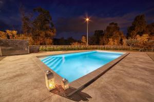 a swimming pool at night with a street light at Il Casale di Monacella in Santa Venerina