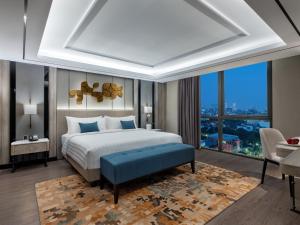 a bedroom with a bed and a large window at Royal Malioboro by ASTON in Yogyakarta