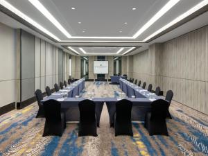 a conference room with tables and chairs and a projector screen at Royal Malioboro by ASTON in Yogyakarta