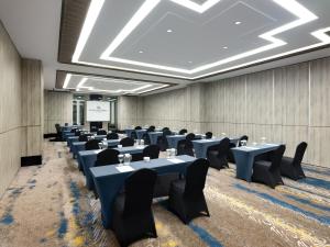 a conference room with tables and chairs and a projection screen at Royal Malioboro by ASTON in Yogyakarta