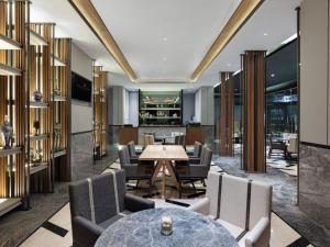 a lobby with a table and chairs and a bar at Royal Malioboro by ASTON in Yogyakarta