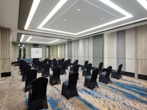 a conference room with chairs and a projection screen at Royal Malioboro by ASTON in Yogyakarta