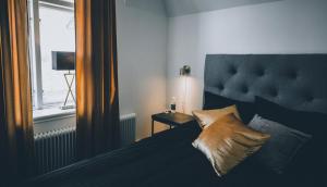 a bedroom with a bed with a large headboard and a window at Frövi hotell in Frövi +10 photos