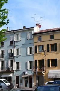 a tall building with cars parked in front of it at Relais De La Place - Downtown in Desenzano del Garda