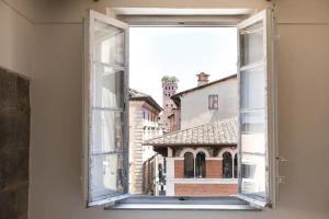 een open raam met uitzicht op een gebouw bij Mario's apartament with AC and wifi in Lucca