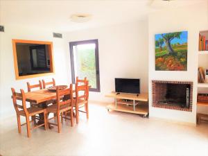 a dining room with a table and chairs and a television at Casa LA PLETERA 367 in L'Estartit