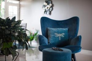 a blue chair with a pillow in a living room at Le Cocon vous accueille avec plaisir ! in Fort-de-France