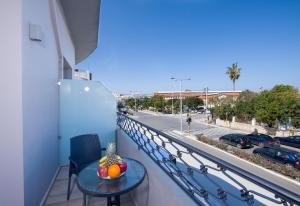 d'un balcon avec une table et une vue sur la rue. dans l'établissement Stoa Suites Chania, à La Canée