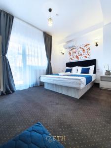 a bedroom with a bed and a large window at ZETH HOUSE in Mamaia Sat/Năvodari