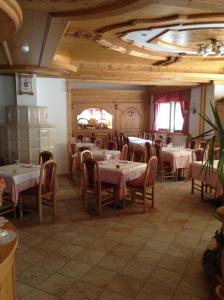 a dining room with tables and chairs and a ceiling at Hotel Pineta in Fiavè