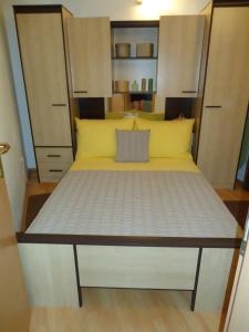 a large bed in a small room with cabinets at Apartment Lucija on the sandy beach in Drvenik Mali