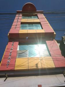 a tall building with a brightly colored building at Vamoose Nirmala in Kailāshahar