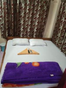 a bed with a knife and a plate on it at Vamoose Nirmala in Kailāshahar