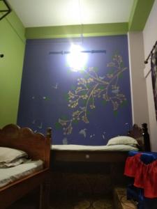 un dormitorio con una pared azul con una luz en él en Vamoose Nirmala, en Kailāshahar