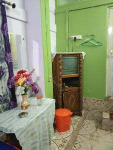 - un salon avec une table et une télévision dans l'établissement Vamoose Nirmala, à Kailāshahar