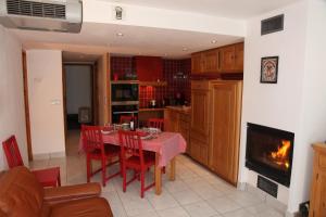 een keuken met een tafel met rode stoelen en een open haard bij Chalet Bouquetin- Loir in Champagny-en-Vanoise