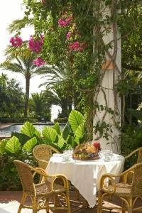 a table with a white table cloth and chairs and flowers at Hurricane Beach Hotel in Tarifa