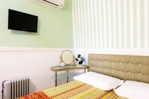 sypialnia z łóżkiem i telewizorem na ścianie w obiekcie Extravacanza Porto w mieście Bari