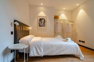 a bedroom with two beds and a table in it at Edificio Fénix by Plaza Mayor Apartamentos in Valladolid
