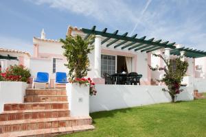 una casa con una parete bianca e un patio di Quinta do Rosal a Carvoeiro