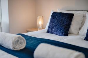a bed with a blue and white blanket on it at Alexandra House in Swansea