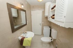 a bathroom with a sink and a toilet and a mirror at DIANA in Crikvenica +34 photos
