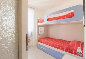 a bedroom with two bunk beds with red sheets at Casetta Pina in San Siro