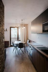 uma cozinha e sala de jantar com mesa e cadeiras em Apartmán Lúčnica em Bystrá