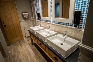 a bathroom with two sinks and a mirror at Brunel Inn in Saltash