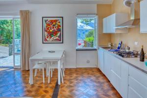 una cucina con tavolo bianco, tavolo e sedie di MARLA House Sea View a Levanto
