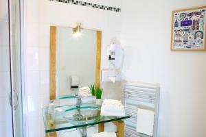 a bathroom with a mirror, a sink, and a dresser at Logis Hôtel Marguerite d'Anjou in Angers