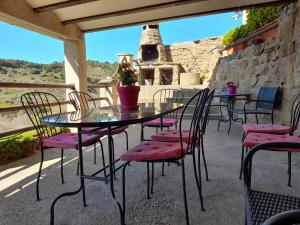 a table and chairs on a patio with a fireplace at Casa Leandron in Murillo de Gállego